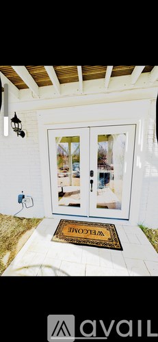 A white door with a glass window and a doormat that says "Welcome".