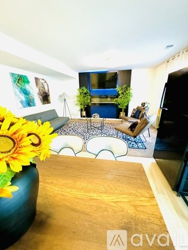 A living room with a couch, a coffee table, and a vase of sunflowers.