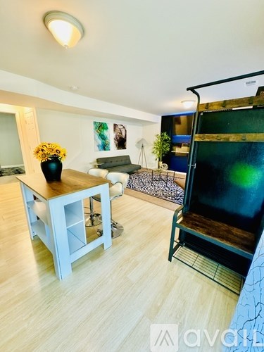 A room with a wooden floor and a table with a vase of flowers on it.