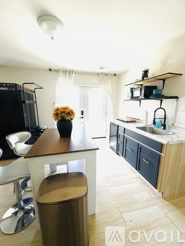 A kitchen with a wooden counter and a trash can.