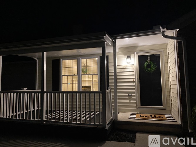 A house with a lit up wreath on the door.