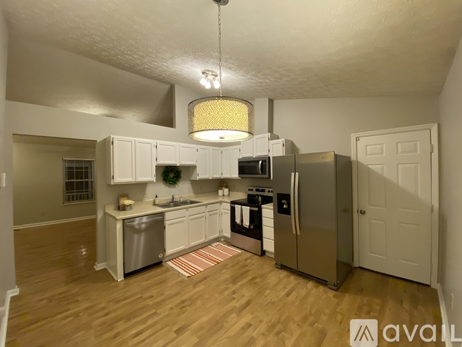 A kitchen with wooden floors and white cabinets.