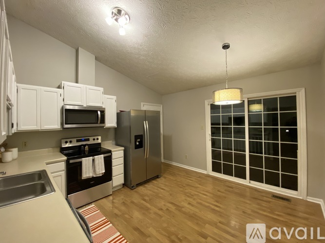 A kitchen with white cabinets and a stainless steel refrigerator.
