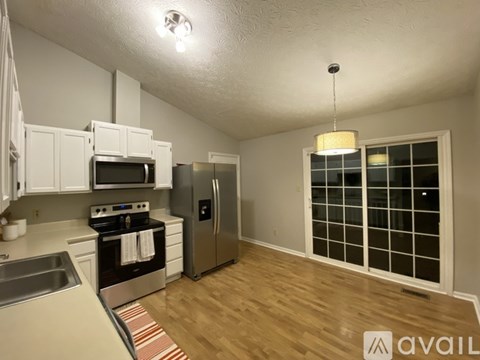 A kitchen with white cabinets and a stainless steel refrigerator.