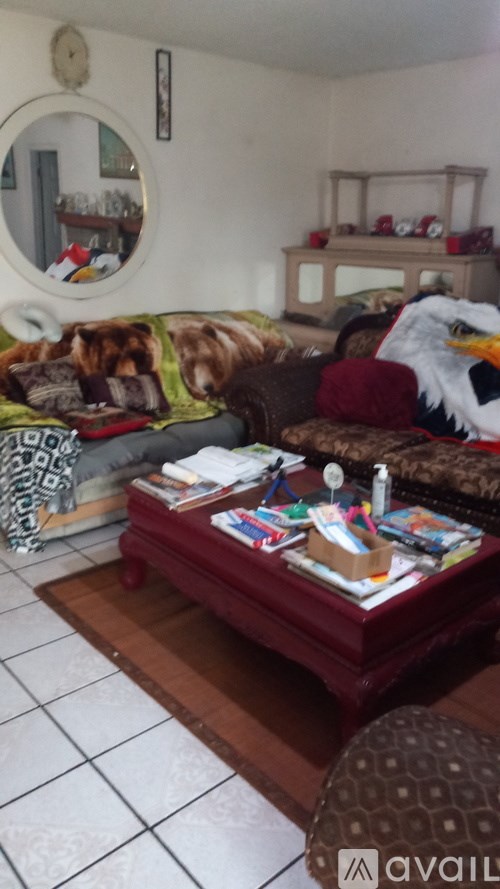 A living room with a couch, a coffee table, and a mirror on the wall.