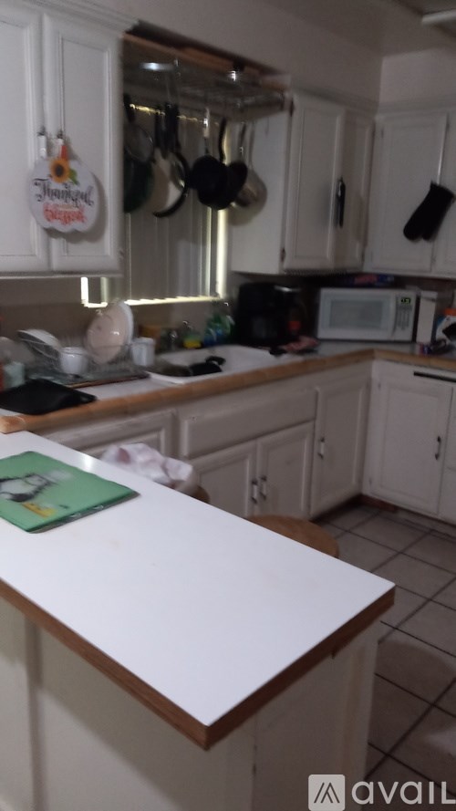 A kitchen with a white counter top and cabinets.