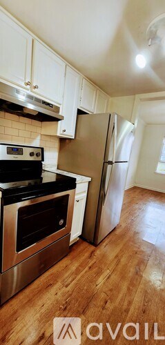 A kitchen with white cabinets and a stainless steel refrigerator.