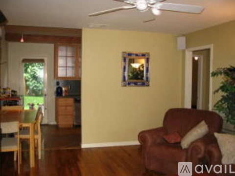 A living room with a brown couch and a ceiling fan.