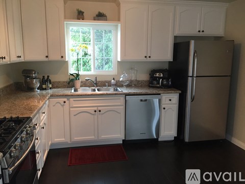 A kitchen with white cabinets and a granite countertop.