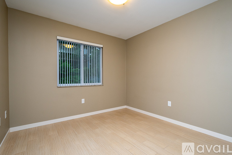 A room with a window and wooden flooring.