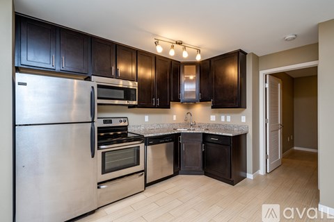 A kitchen with black cabinets and stainless steel appliances.