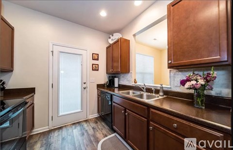 A kitchen with wooden cabinets and a white door.