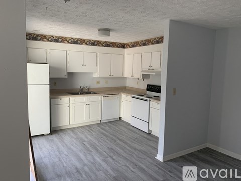 A kitchen with white cabinets and appliances is available for rent.
