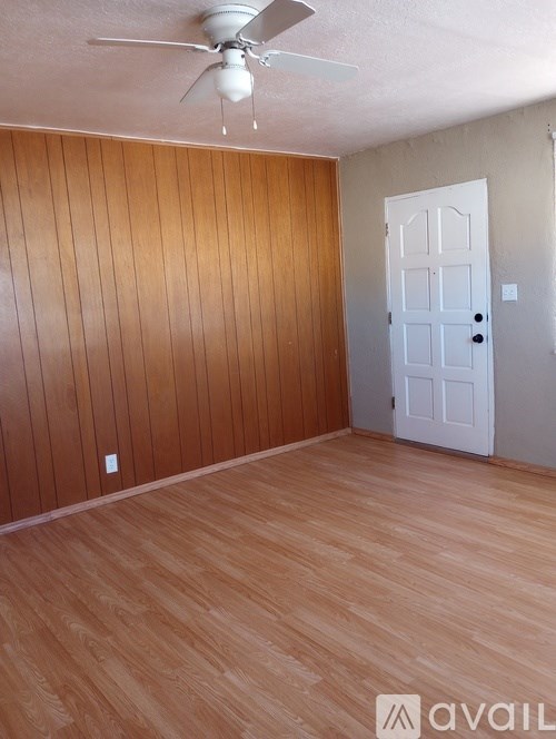 A room with wooden flooring and a white door.