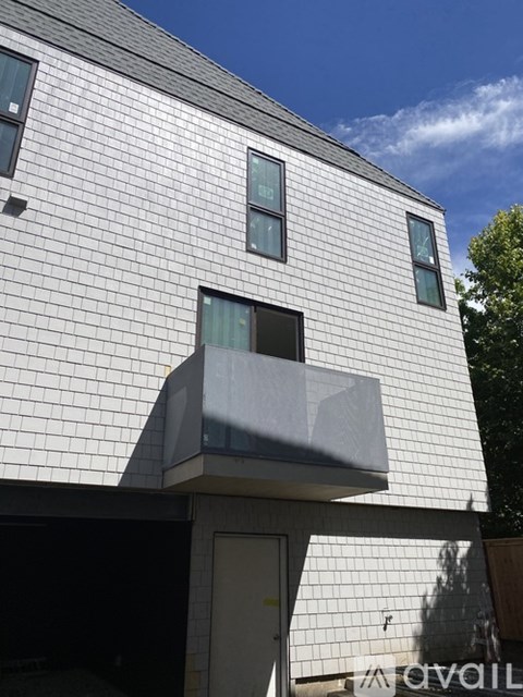 A modern house with a white facade and a balcony.