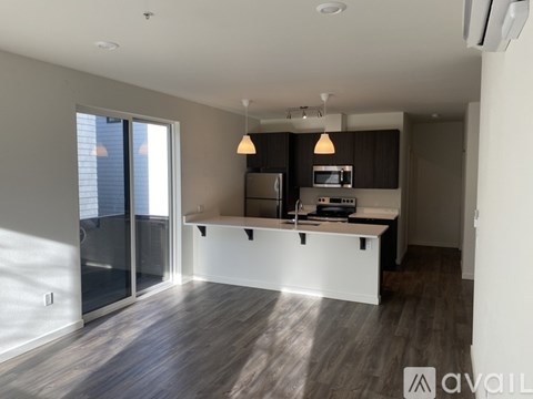 A kitchen with a sink, cabinets, and pendant lights.