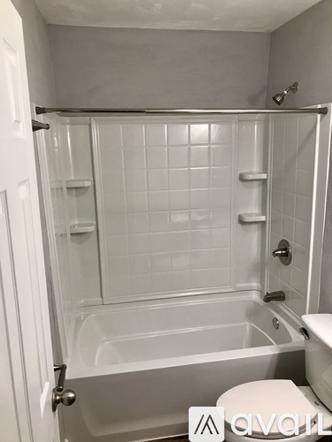 A white bathroom with a glass shower door and a toilet.