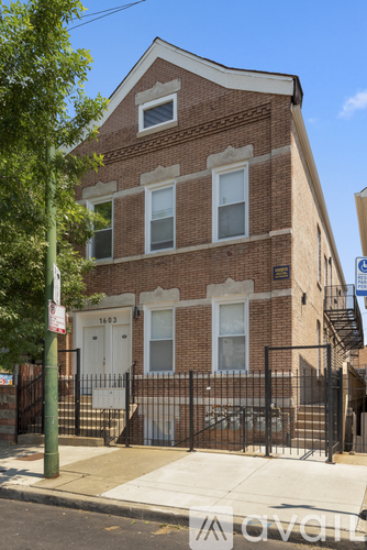 A brick building with a black gate in front.