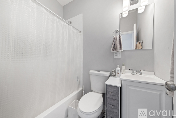 A white bathroom with a toilet, sink, and shower.