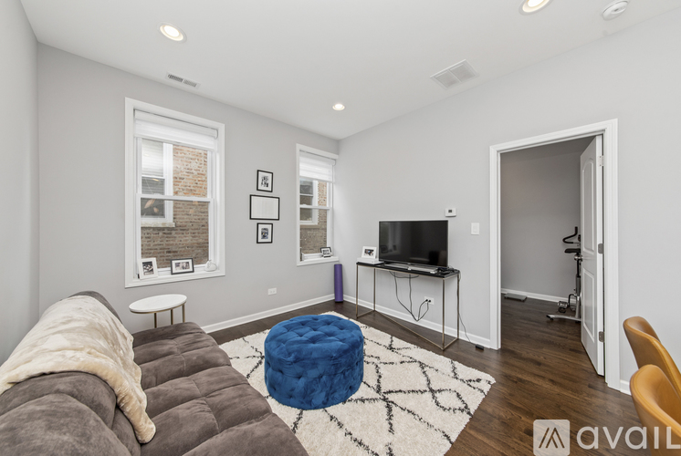 A living room with a grey couch and a blue ottoman.