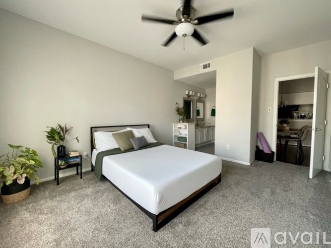 A bedroom with a large bed and a ceiling fan.