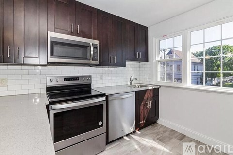 A kitchen with dark brown cabinets and stainless steel appliances.
