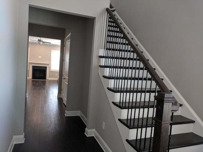 A staircase with a black metal railing and wooden steps.