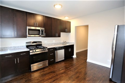 A kitchen with dark brown cabinets and a white counter top.