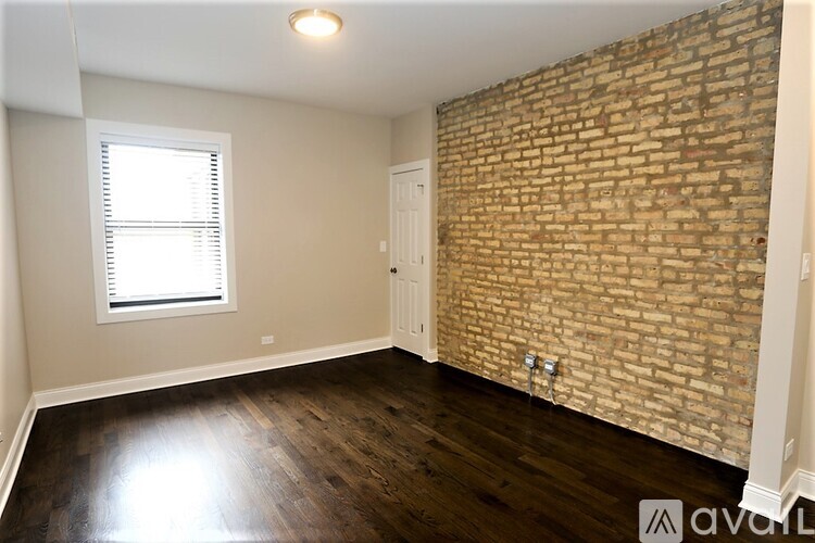 A room with a brick wall and wooden flooring.