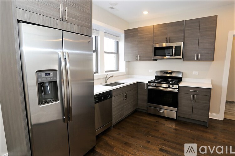 A modern kitchen with a stainless steel refrigerator and oven.