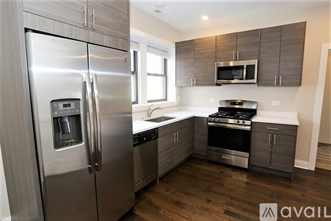 A modern kitchen with a stainless steel refrigerator and oven.
