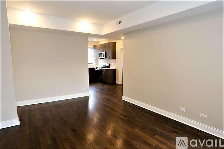 A spacious room with wooden floors and white walls.