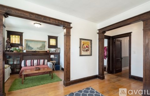 A living room with a green rug and a wooden bench.