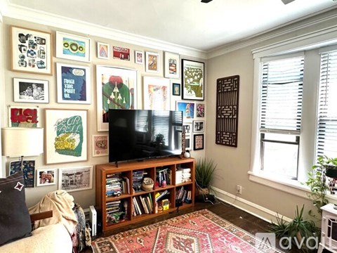 A living room with a television and a wall of pictures.
