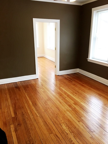 A room with brown wooden floors and a white door.