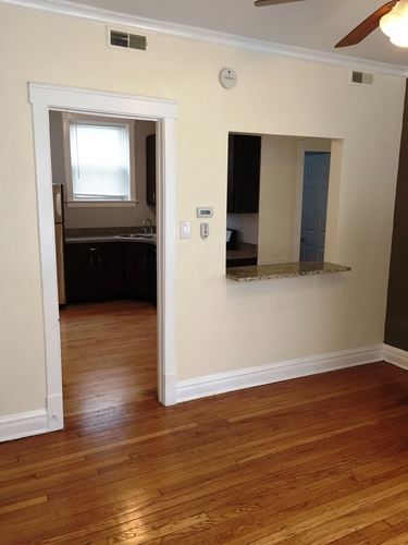 A room with a wooden floor and a mirror on the wall.