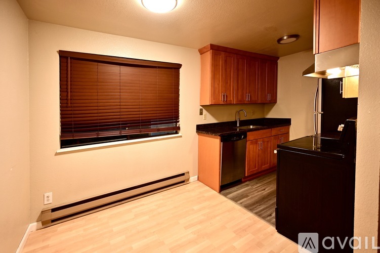 A kitchen with wooden cabinets and a black countertop.