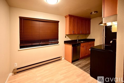 A kitchen with wooden cabinets and a black countertop.