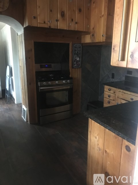 A kitchen with wooden cabinets and a black countertop.