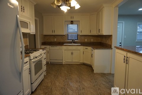 A kitchen with white appliances and cabinets.