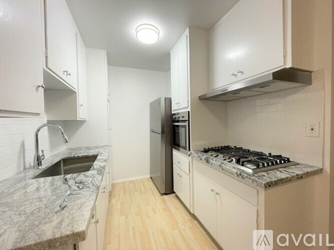 A kitchen with a granite countertop and stainless steel appliances.
