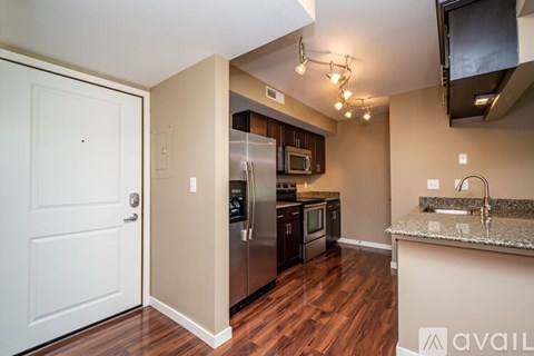 A kitchen with a refrigerator, microwave, and oven.