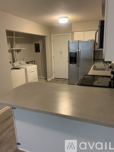 A kitchen with a white fridge and a stainless steel counter.