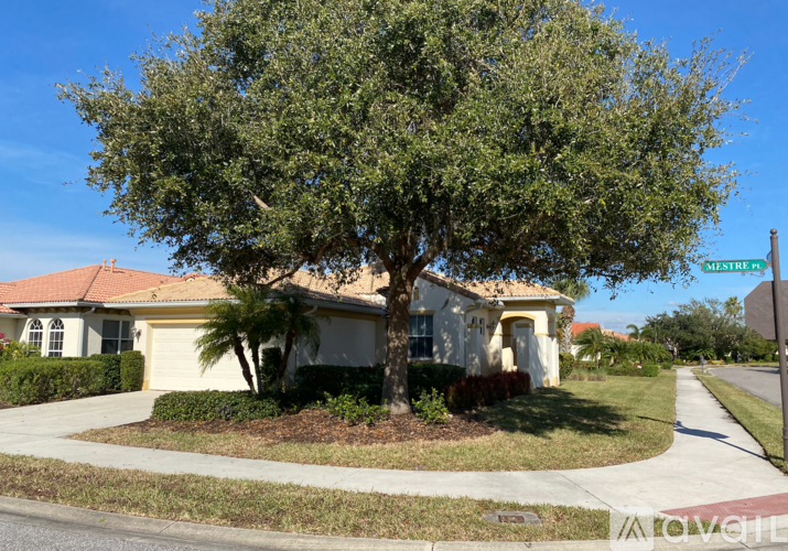 A tree in front of a house with a sign that says Mestres.
