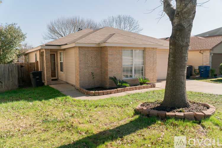 A house with a brown roof and a tree in front.