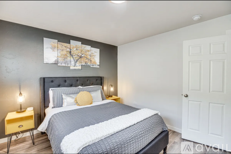 A bedroom with a large bed and a painting on the wall.
