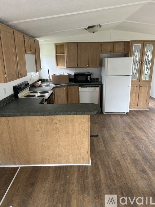 A kitchen with wooden cabinets and a white fridge.