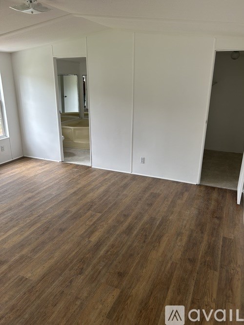 A room with wooden flooring and white walls.