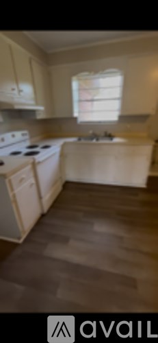 A kitchen with white cabinets and a window.