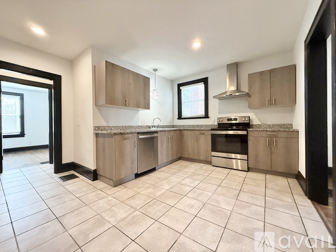A kitchen with a stove top oven and a window.